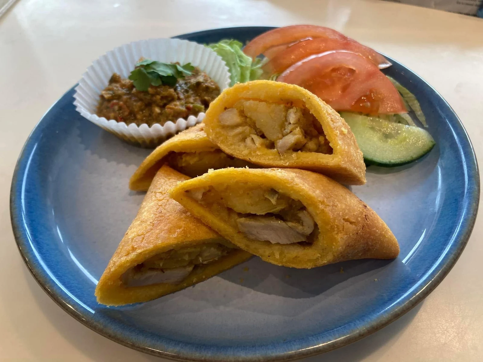 Golden filled pastries served with salad and a savoury side